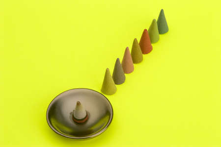 Multi coloured Incense cones against a bright coloured background.の写真素材