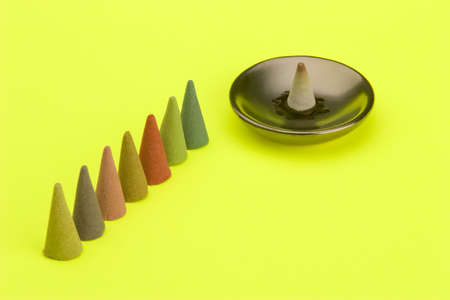 Multi coloured Incense cones against a bright coloured background.の写真素材