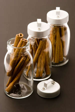 Cinnamon sticks in glass pots, studio shot, close upの写真素材