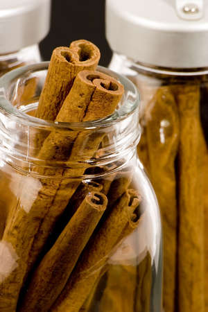 Cinnamon sticks in glass pots, studio shot, close upの写真素材