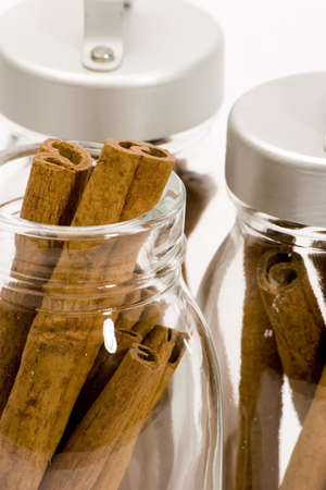 Cinnamon sticks in glass pots, studio shot, close upの写真素材