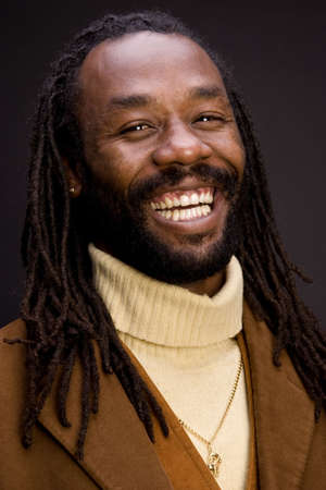 A black man with dreadlock hair isolated on a black background.の写真素材