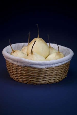 A basket of Asian pear fruit on a blue linen background.の写真素材