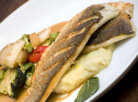A dish of grilled seabass with vegetables.