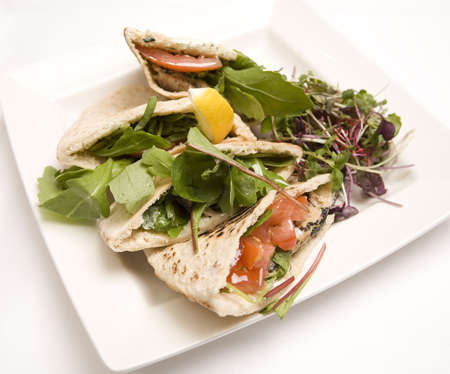 Pitta bread filled with a tuna salad on a white plate.の写真素材