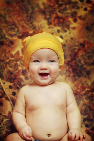 Happy Baby boy posing in the yellow hat and laughsの写真素材