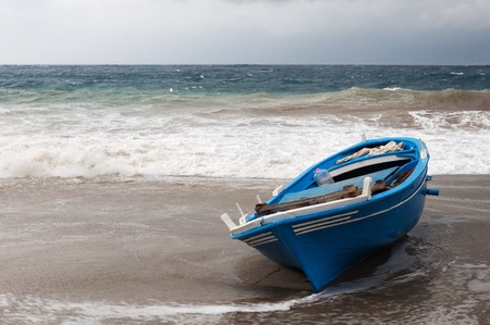 the boat in danger of being dragged off by the sea の写真素材