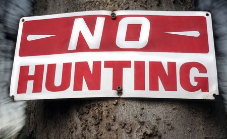 Distressed no hunting sign. Background blurred with flash drag.の写真素材