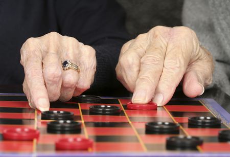 Close up of senior adult hands and checkers