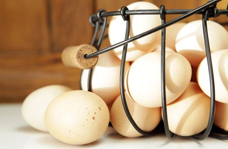 Farm fresh eggs in a wire basket at sunrise. Shallow depth of field.の写真素材