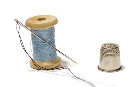 series object on white: thimble with sewing needle