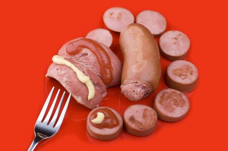 object on red - food sausage with ketchup and mustardの写真素材