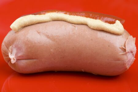object on red - food sausage with ketchup and mustardの写真素材