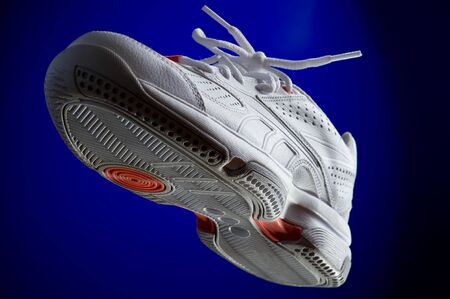 object on blue - white sneakers close up