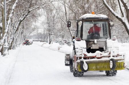 winter snow removal a small tractor in the parkのeditorial素材