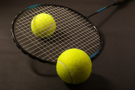 tennis ball and racket on dark backgroundの写真素材