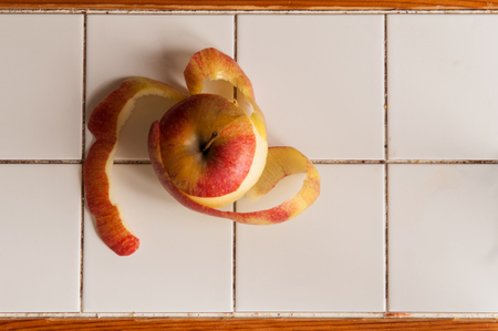 peeled apple on tile  white kitchen tableの写真素材