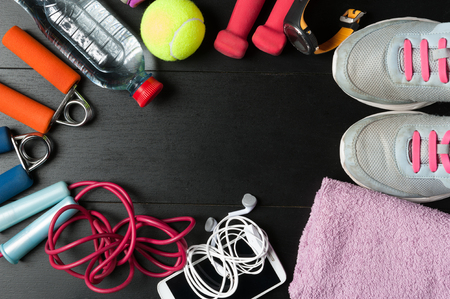 Big fitness set, sneakers, dumbbells, water bottle, mobile phone with headphones and jumping ropeの写真素材