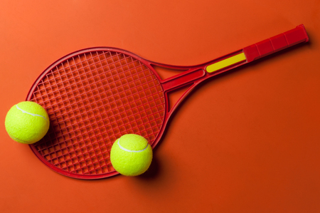 tennis racket and ball on red backgroundの写真素材