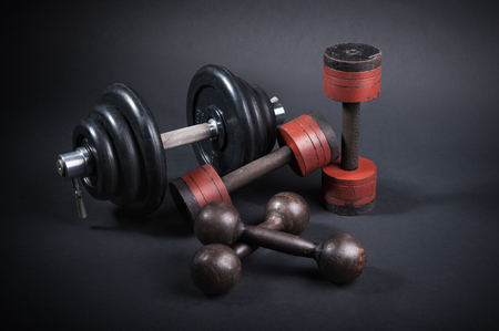 dumbbell with typesetting discs weighting on dark backgroundの写真素材
