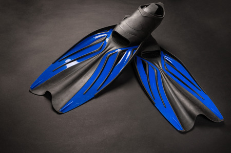 rubber black and blue flippers on dark background
