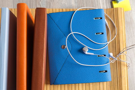 blue notebook with earphones and sticky on tableの写真素材