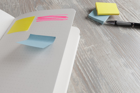 notebook with square sticky on wood background