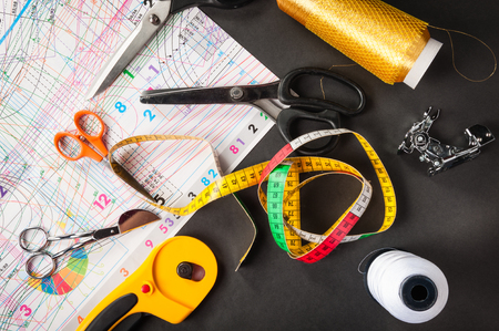 sewing tools thread with scissors and measuring tape on darkの写真素材