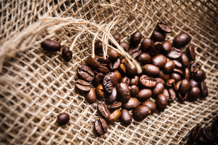 sprinkled roasted coffee beans on burlapの写真素材