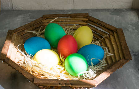Eggs in a wooden plate in the sunshineの写真素材