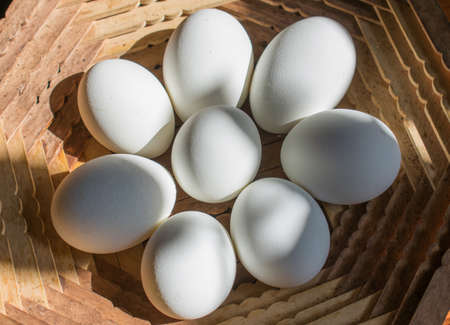 Chicken eggs in a wooden plate
