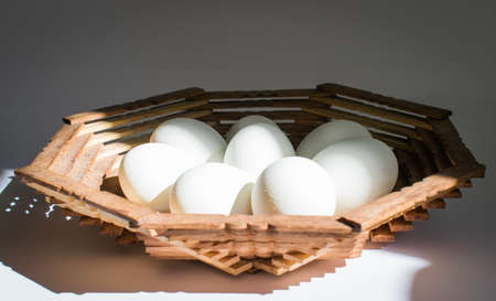 Chicken eggs in a wooden plateの写真素材