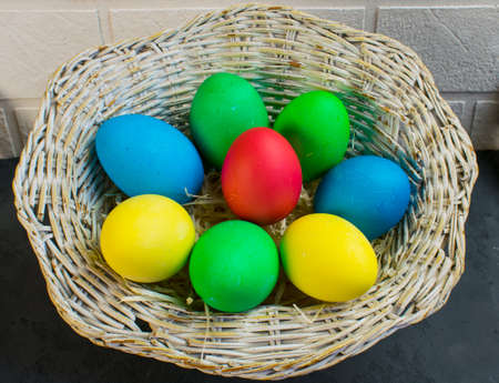 Easter eggs in a basket on the tableの写真素材