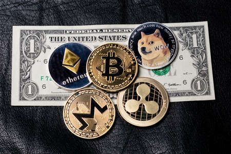 Dollar and coins of cryptocurrency on a dark leather backgroundの写真素材