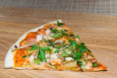 slice of pizza on a wooden cutting boardの写真素材