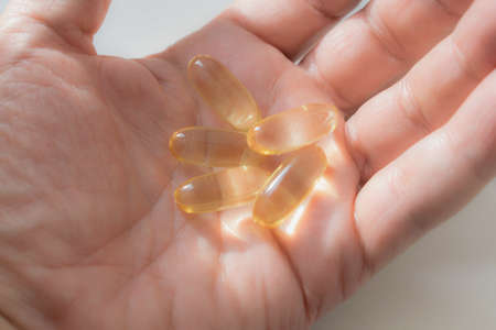 Fish oil tablets in the palm of your handの写真素材