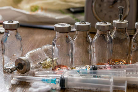 syringes after injections and medicine jars on the tableの写真素材