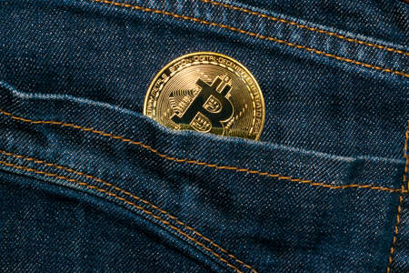 Bitcoin gold coin in jeans pocket investment concept