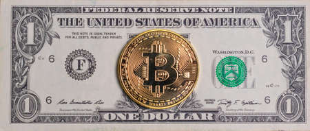 Gold coin bitcoin on the background of the american dollarの写真素材