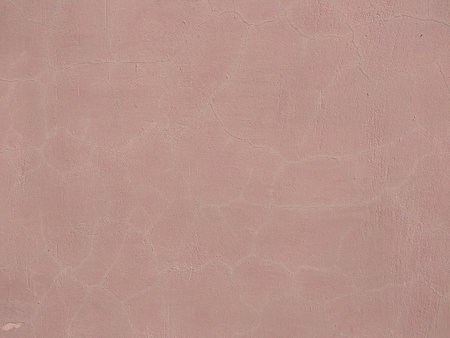 Pink plaster with cracks on the wall texture backgroundの写真素材