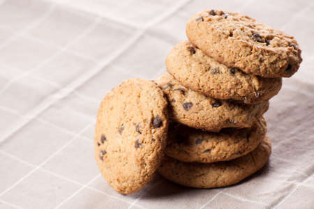 Chocolate chip cookies on brown napkin.