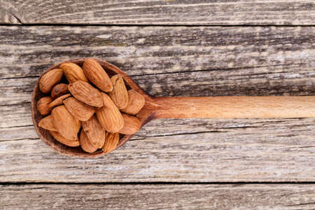 Almonds on a wooden spoon.の写真素材