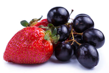Tasty strawberry and grapes on a white background.の写真素材