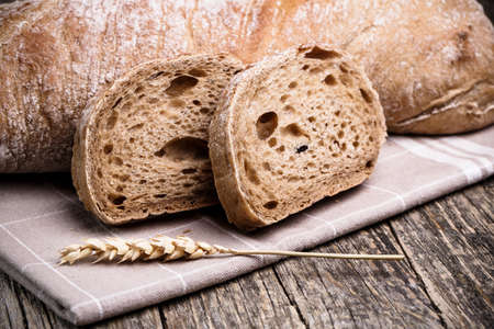 Slices of bread with rye on a wooden background.