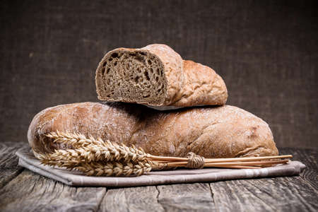 Slices of bread with rye on a wooden background.