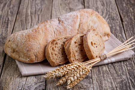 Slices of bread with rye on a wooden background.の写真素材