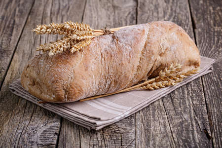Slices of bread with rye on a wooden background.の写真素材