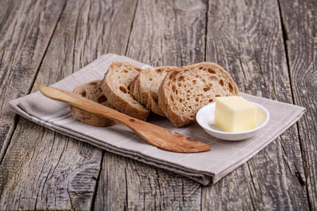 Slices of bread with rye on a wooden background.の写真素材
