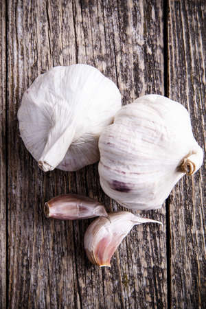 Some garlics on a wooden background.の写真素材