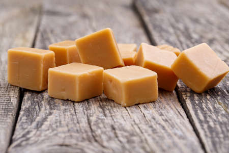 Delicious caramel candies on wooden background.の写真素材